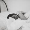 grayscale photo of sleeping woman lying on bed