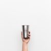 person holding gray stainless steel drinking cup