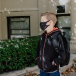 man in black leather jacket wearing white and orange backpack