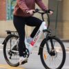 person in red jacket and black pants riding black and white bicycle