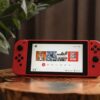 red nintendo switch on brown wooden table