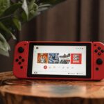 red nintendo switch on brown wooden table