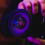 person holding black and blue camera lens